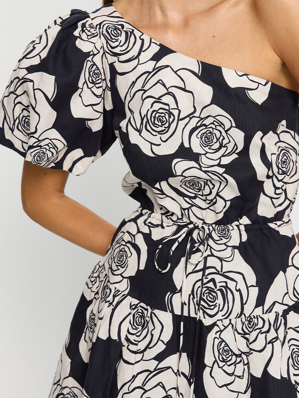 Carmen One Shoulder Mini Dress KIVARI | Model wears navy and white floral mini dress close up