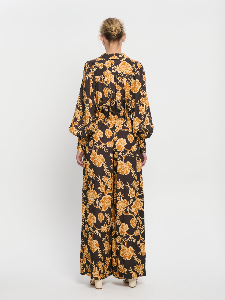 Kaia Jumpsuit KIVARI | Model wears black and orange floral jumpsuit back view