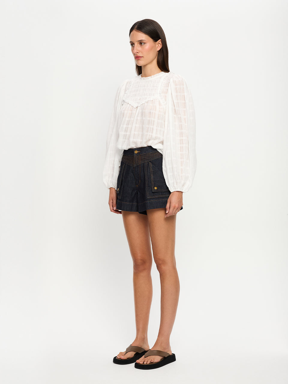 Woman wearing a white blouse and shorts on a white background