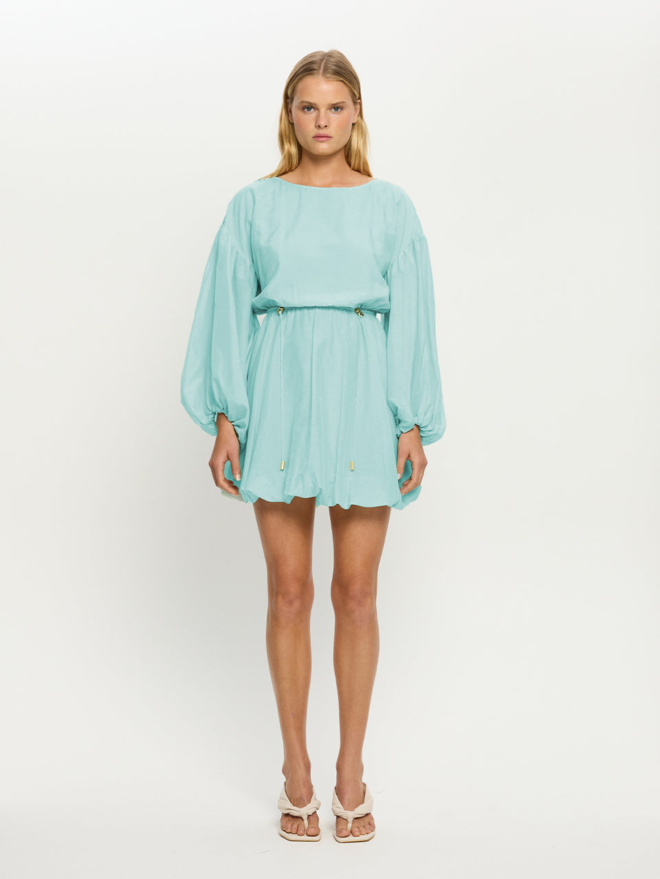 Woman wearing a light blue dress on a white background