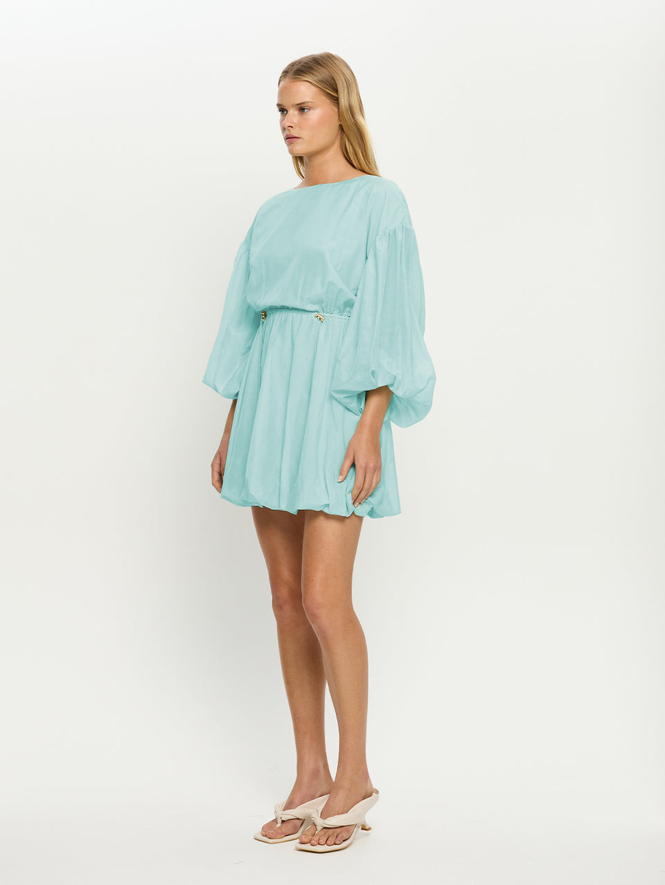 Woman wearing a light blue dress on a white background