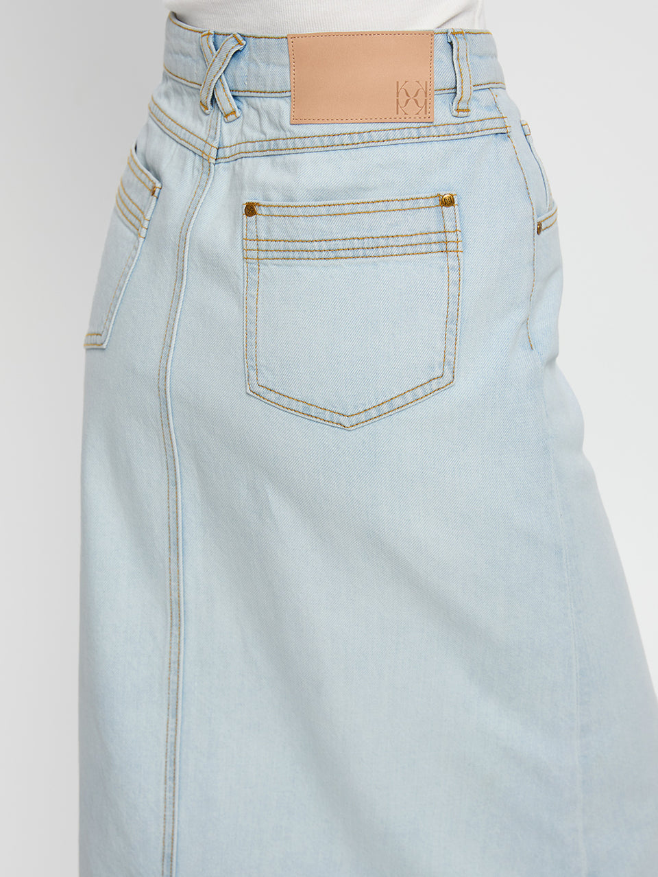 Zoya Skirt KIVARI | Model wears pale blue denim skirt close up