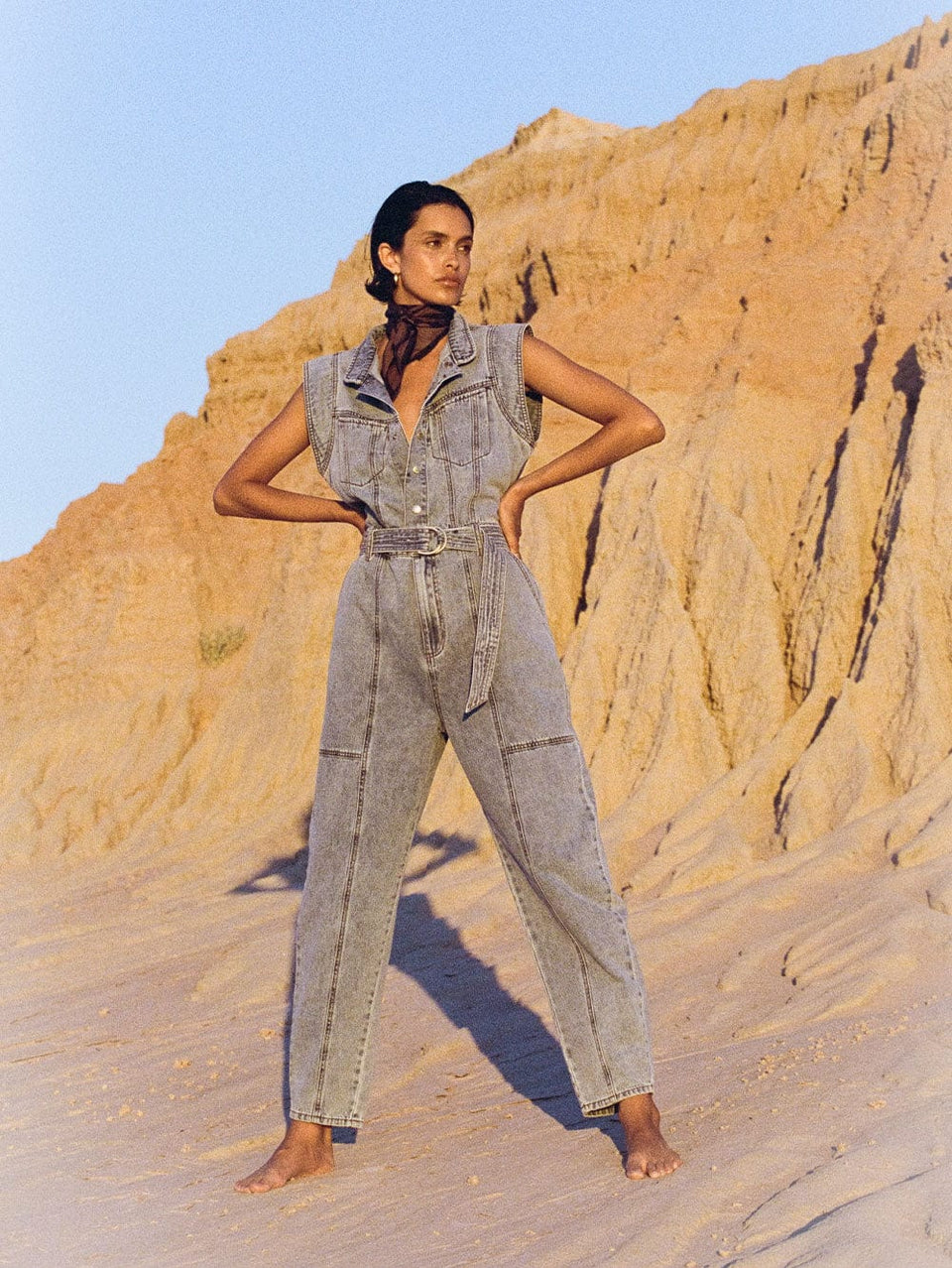 KIVARI Azalia Boilersuit | Model wearing Denim Boilersuit in front of rock