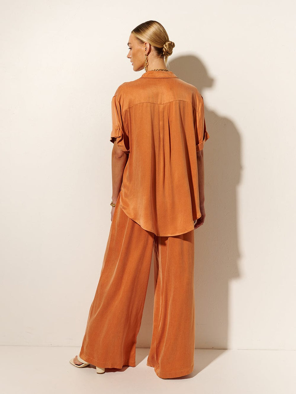 KIVARI Bianca Shirt | Model wears Orange Shirt Back View