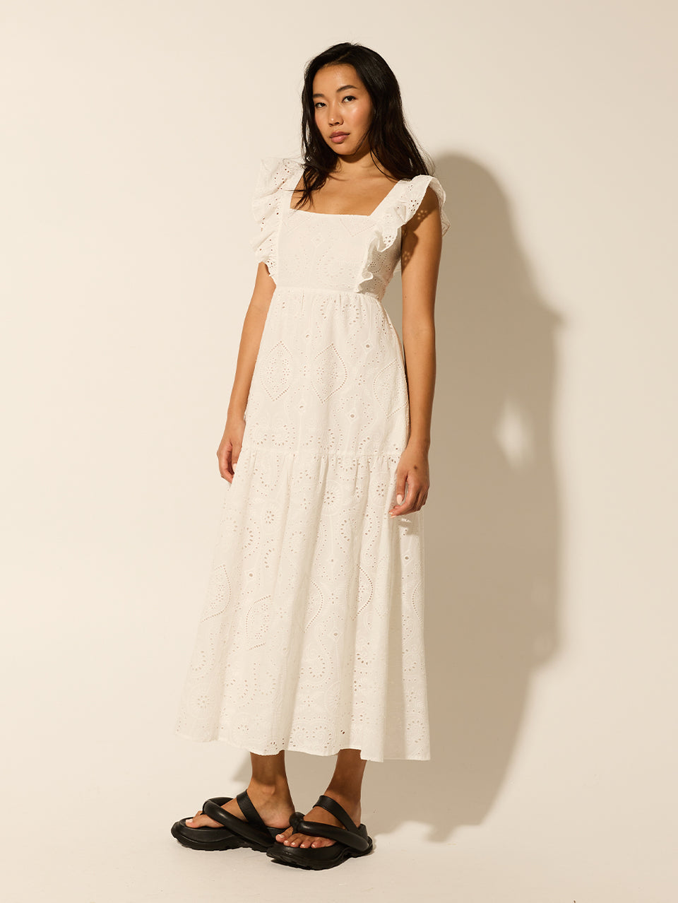 Clove Midi Dress KIVARI | Model wears white embroidered midi dress side view