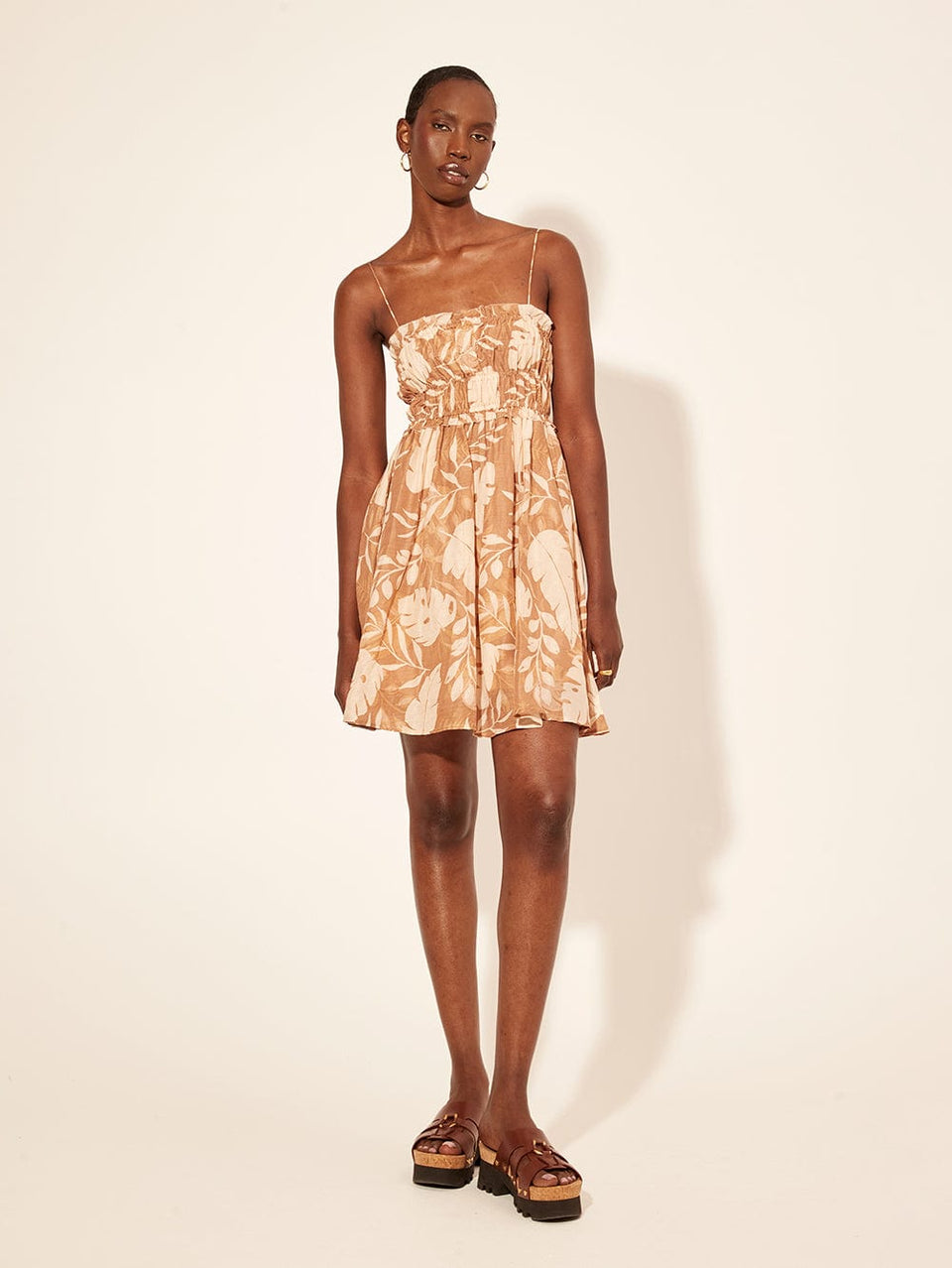 Cove Mini Dress KIVARI | Model wears neutral coloured leaf print
