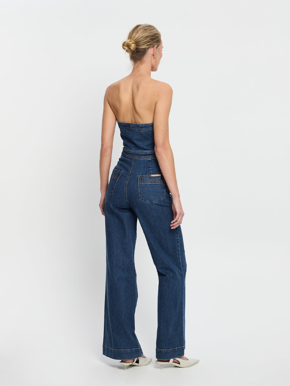 Dani Jumpsuit Indigo KIVARI | Model wears indigo blue denim strapless jumpsuit back view