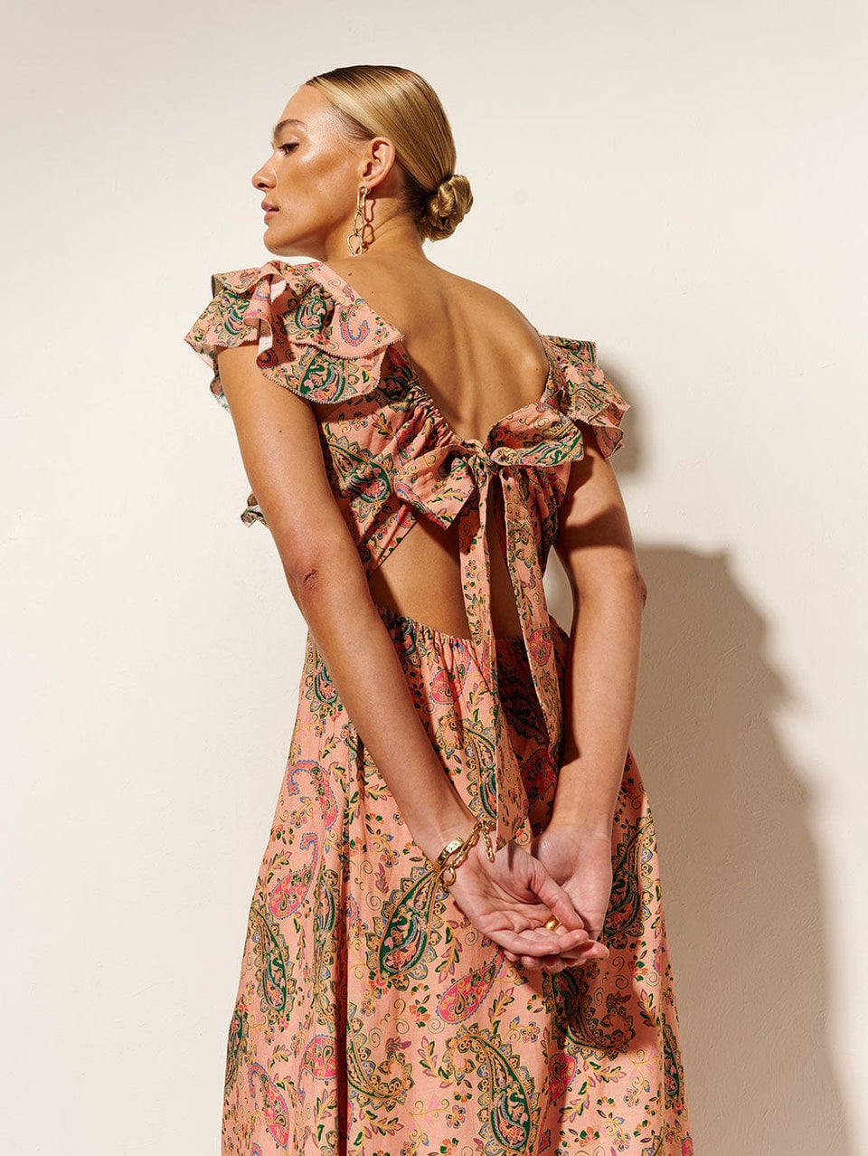 Isha Ruffle Maxi Dress KIVARI | Model wears ruffle pink paisley maxi dress back view