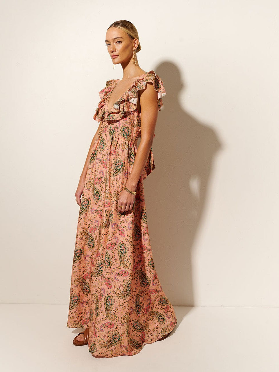 Isha Ruffle Maxi Dress KIVARI | Model wears ruffle pink paisley maxi dress  side view
