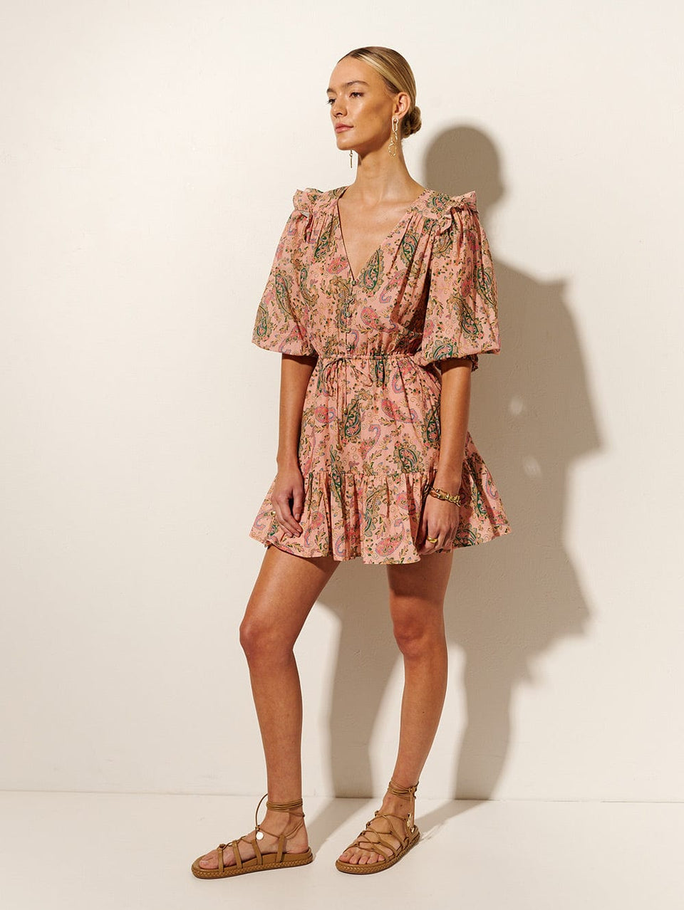 Isha Ruffle Mini Dress KIVARI | Model wears ruffle pink paisley mini dress side view