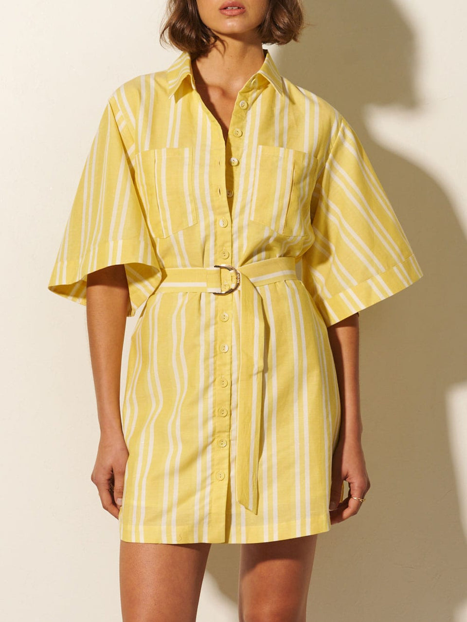 Lola Shirt Dress KIVARI | Model wears yellow and white striped shirt dress close up