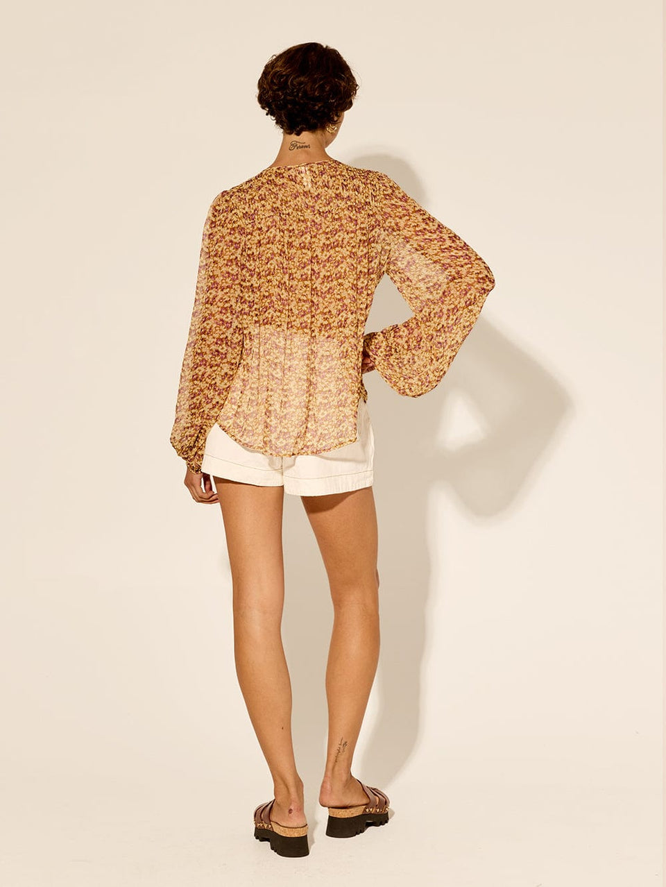 Mia Blouse KIVARI | Model wears orange and purple ditsy printed blouse back view