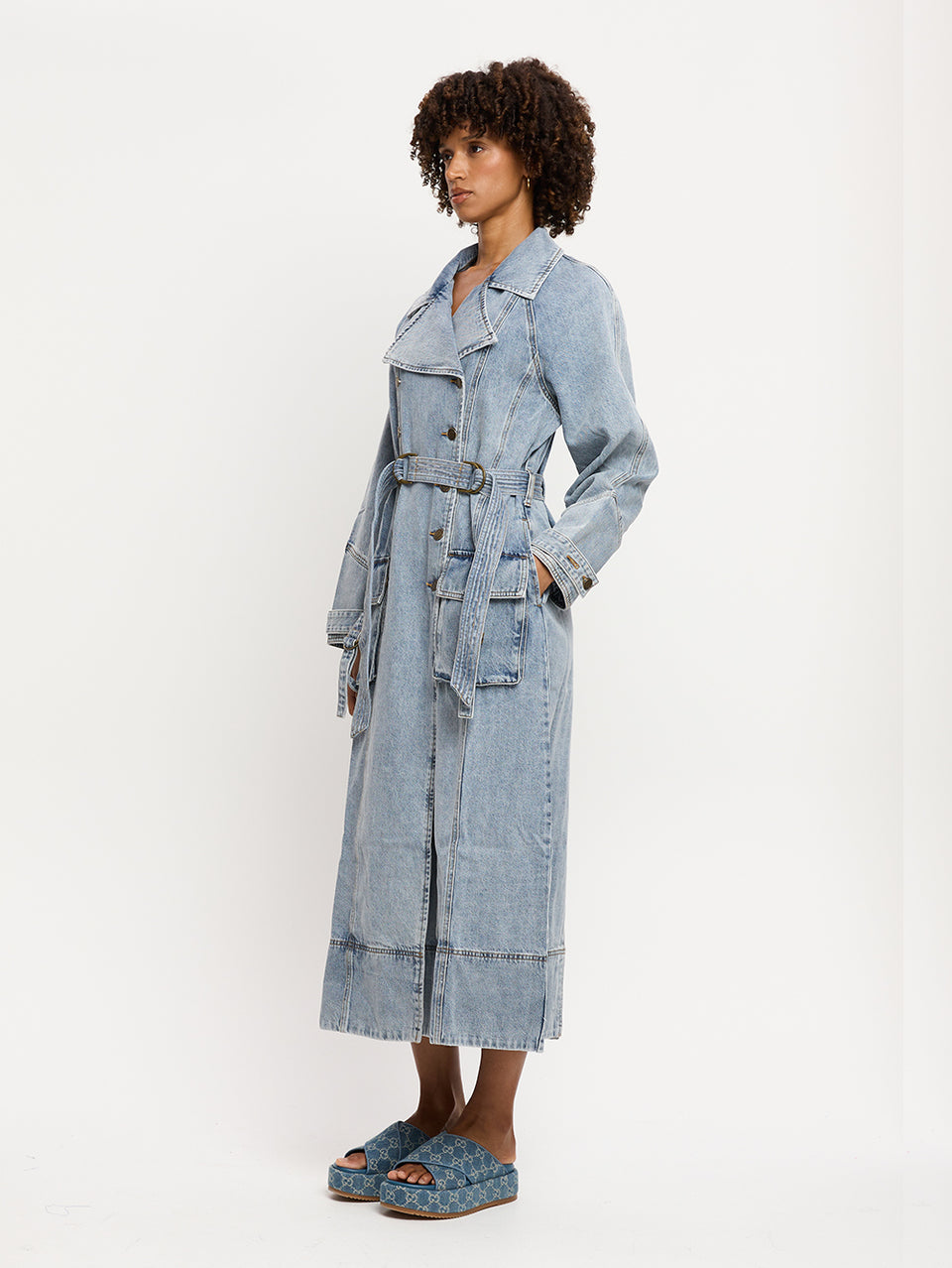 Olivia Denim Trench Coat KIVARI | Model wears light blue wash denim trench coat side view