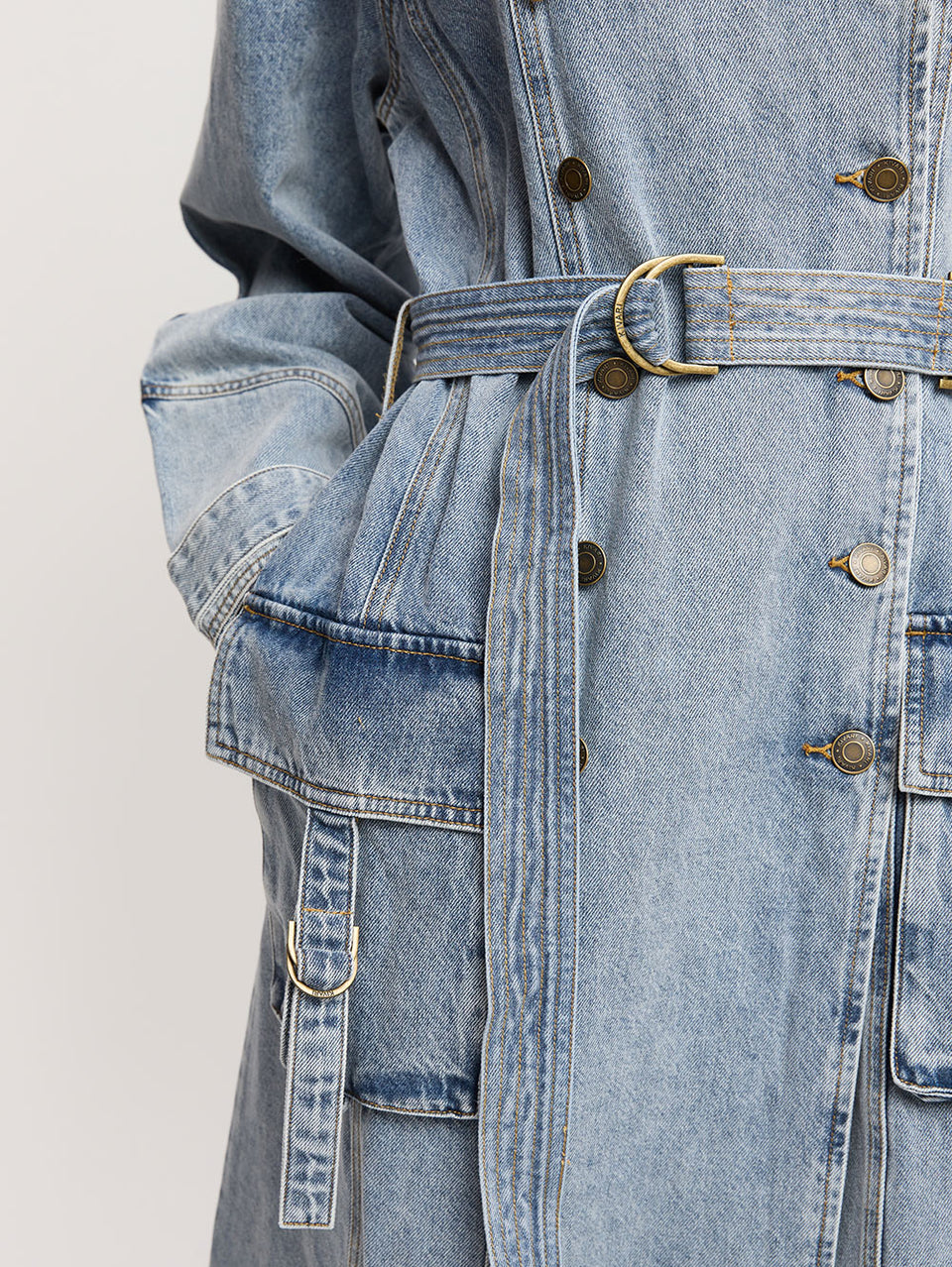 Olivia Denim Trench Coat KIVARI | Model wears light blue wash denim trench coat detail