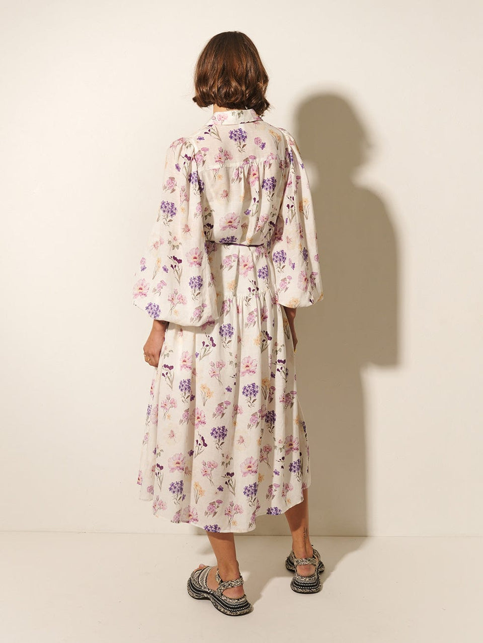 Phoebe Midi Dress KIVARI | Model wears ivory and purple floral midi dress back view