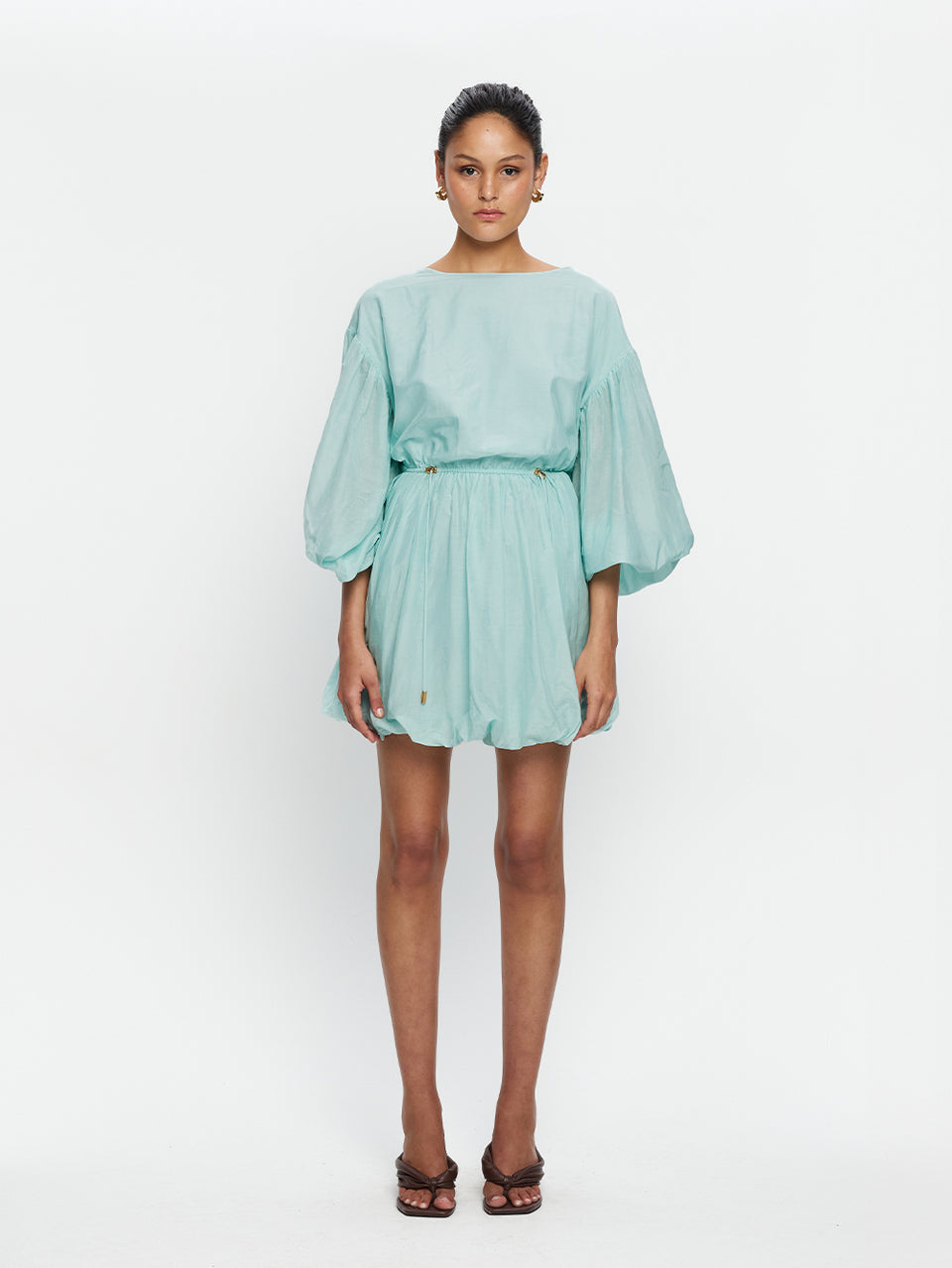 Woman wearing a light blue dress on a white background