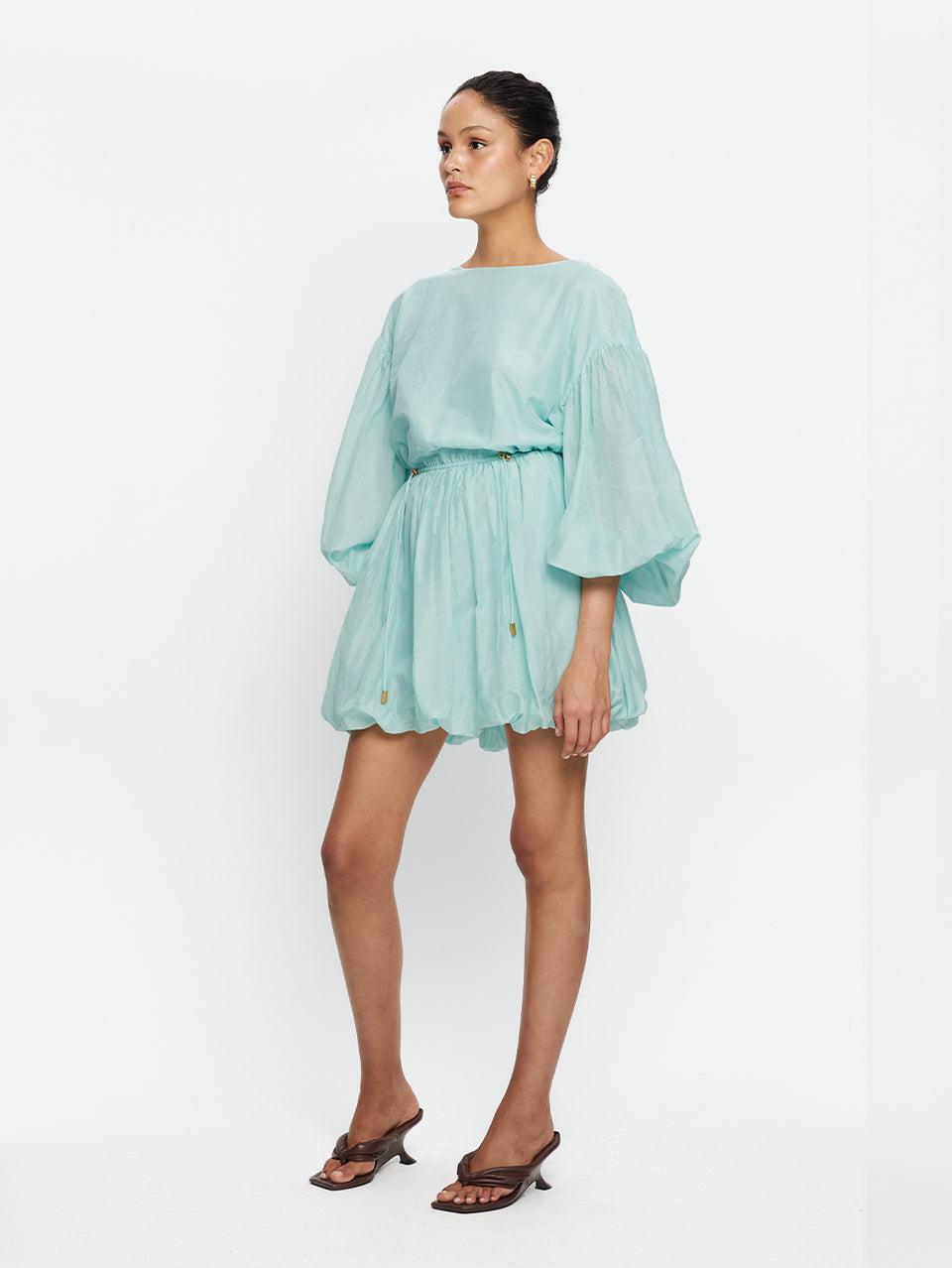 Woman wearing a light blue dress on a white background