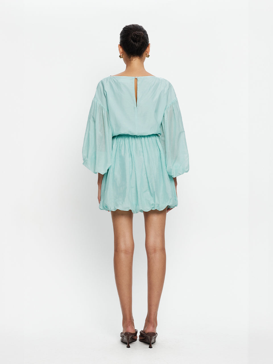 Person wearing a light blue dress on a white background
