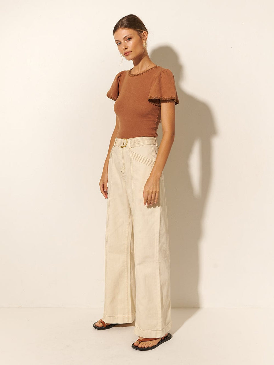 KIVARI Tallulah Tee | Model wears Brown Tee Side View