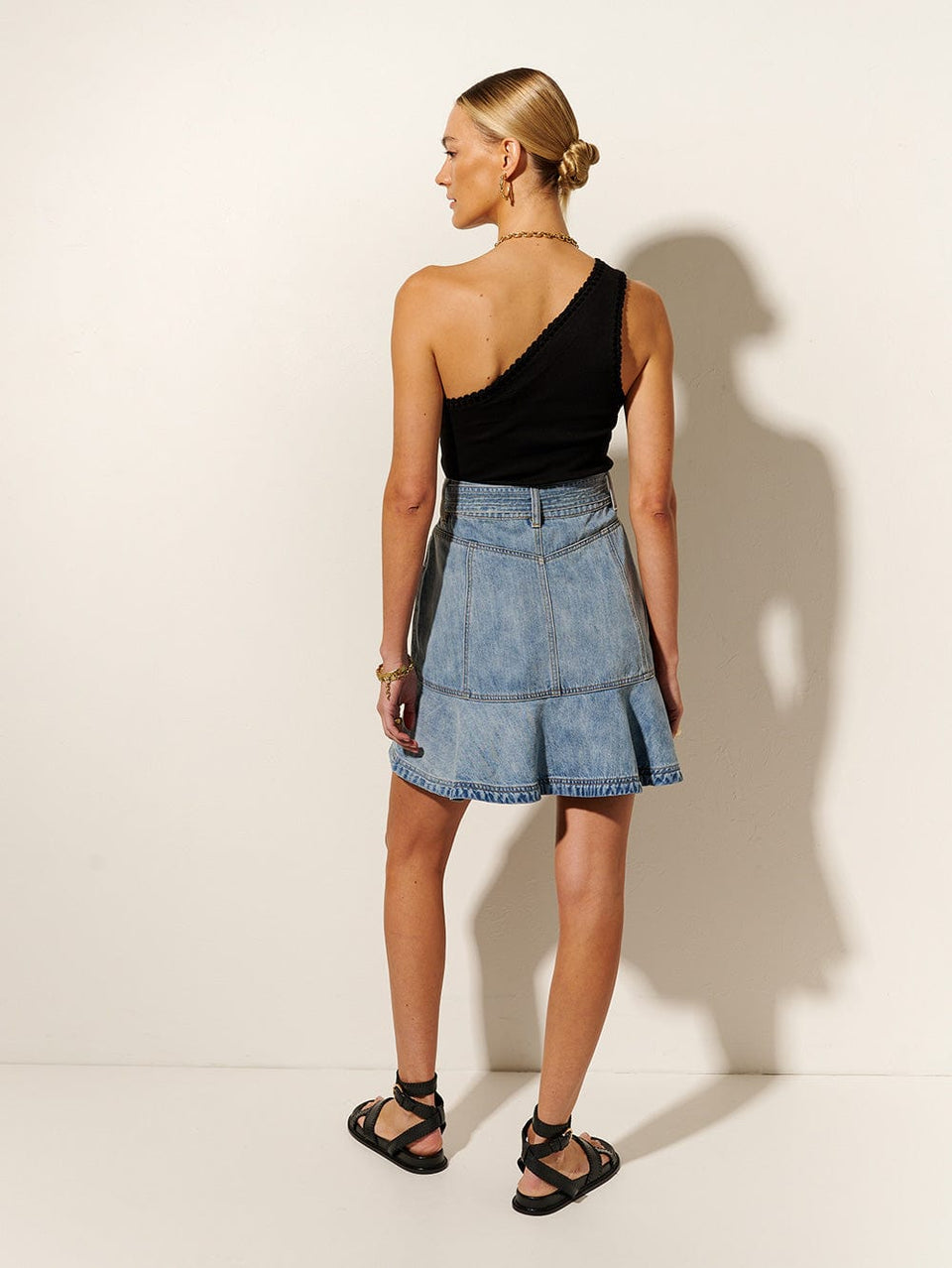 Theo Mini Skirt KIVARI | Model wears light blue denim skirt back view