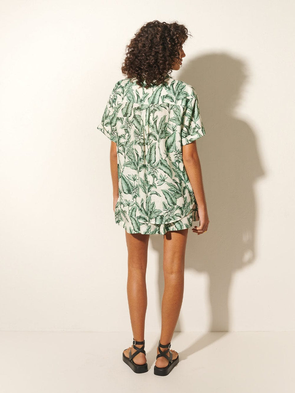 Tropico Short KIVARI | Model wears palm leaf print shorts back view