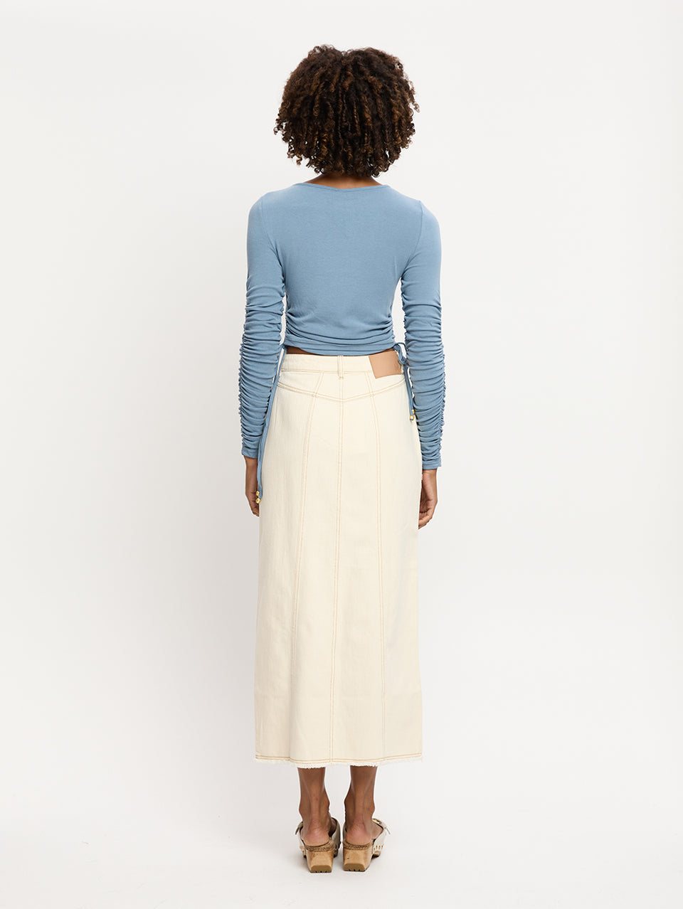 Vanessa Top KIVARI | Model wears blue jersey knit long sleeve top back view